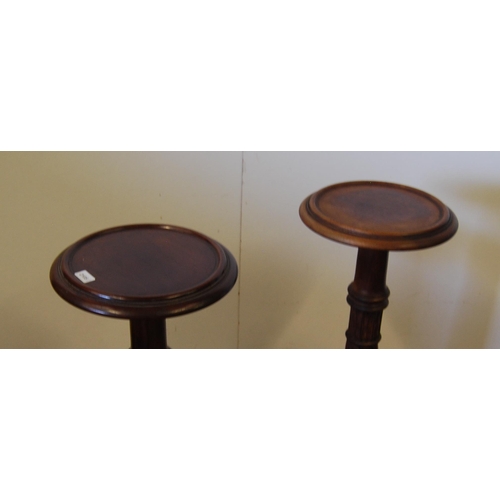 309 - Pair of mahogany torchères, c. early 20th century, each with a saucer top above turned reeded column... 