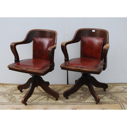 323 - Pair of early 20th century oak revolving captain's desk chairs upholstered in later Rexine, metal ad... 