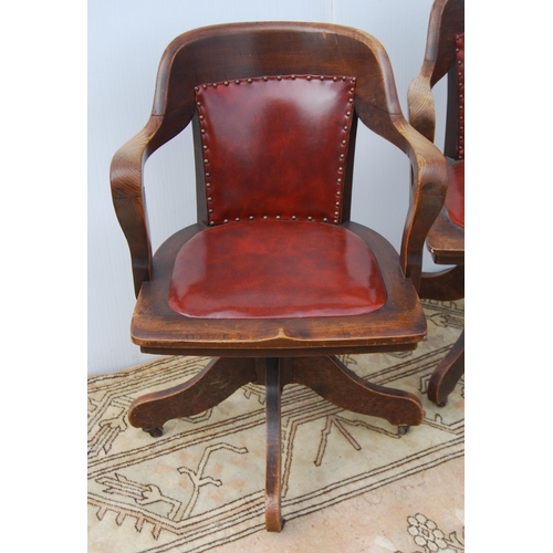 323 - Pair of early 20th century oak revolving captain's desk chairs upholstered in later Rexine, metal ad... 