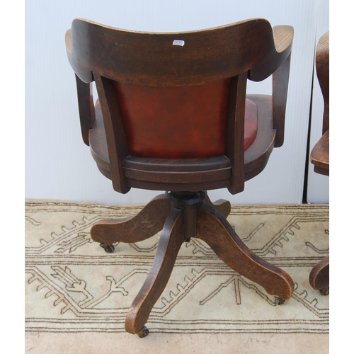 323 - Pair of early 20th century oak revolving captain's desk chairs upholstered in later Rexine, metal ad... 