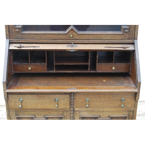 332 - Oak secrétaire bookcase with glazed bookcase section above a tambour roller shutter enclosing fitted... 