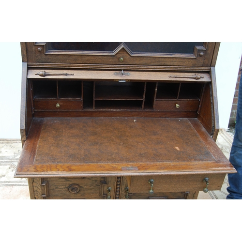 332 - Oak secrétaire bookcase with glazed bookcase section above a tambour roller shutter enclosing fitted... 