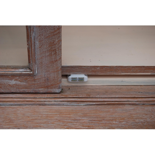 334 - Stained wood bookcase by Maple & Co., with two astragal glazed doors enclosing a shelved interio... 