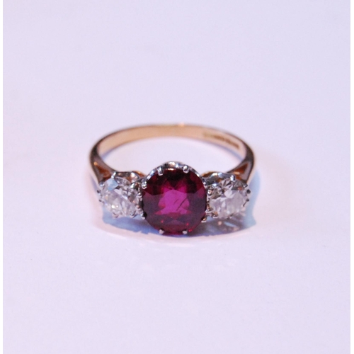 3 - Three-stone ruby and diamond ring, the almost-circular ruby approximately 6mm x 7mm, with two old-cu... 