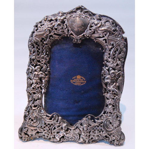 90 - Silver photograph frame pierced with putti and scrolls, by W Comyns, 1895, 22cm x 17cm, and another.... 