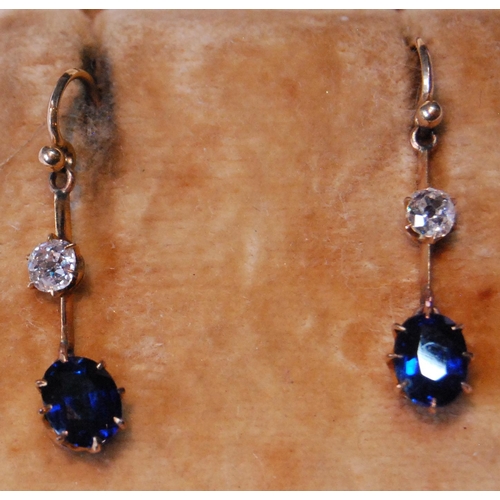 7 - Pair of drop earrings, each with oval sapphire dependant from a diamond collet on knife edge.