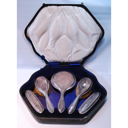 100 - Silver five-piece toilet set with moulded edges, cased.