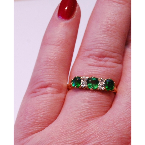 67 - Demantoid garnet three-stone ring with four diamond brilliants, '18ct' (uncertificated), size S.