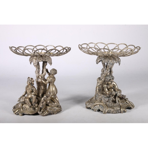 40 - Cast metal plate stands likely from epergne set, one with boys fishing the other with children harve... 