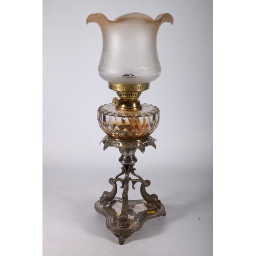 390 - Duplex oil lamp circa early 20th century with later glass shade above glass reservoir and repousse d... 