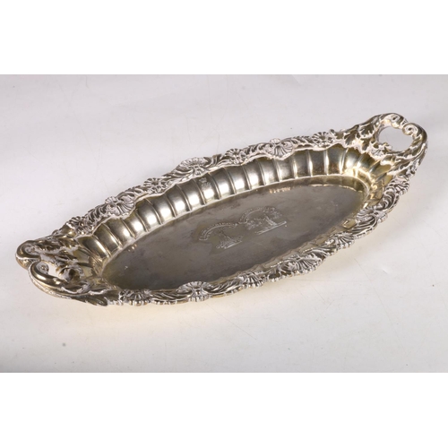 76 - George III gilt silver oval dish with twin handles, chased cast scroll and shell border with two fam... 