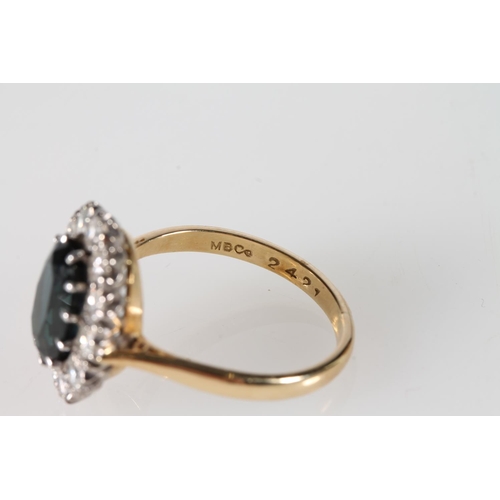 114 - 18ct gold cluster ring with twelve diamonds encircling blue/green oval cut stone, size P, 4.9g