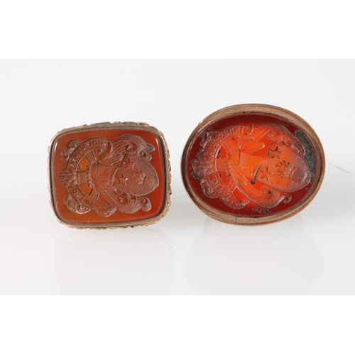 123 - Two yellow metal seals with matching carnelian intaglios with family crests, 3.5cm.