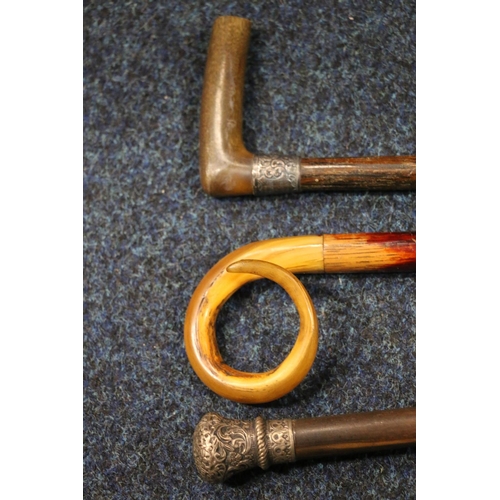 398 - Group of three walking sticks, one with a white metal cap, another with horn handle and white metal ... 