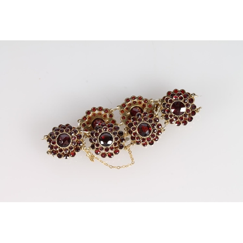 179 - 9ct gold and garnet flowerhead clusters bracelet, 9cm, 24.1g