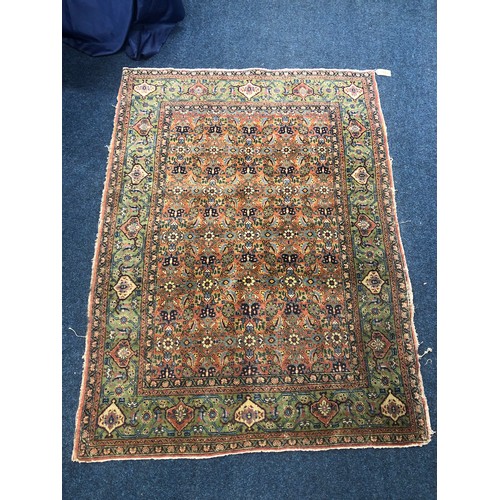 556 - Persian rug, the brick field with floral design and a pale green border, 184 x 132cm.