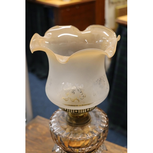 390 - Duplex oil lamp circa early 20th century with later glass shade above glass reservoir and repousse d... 