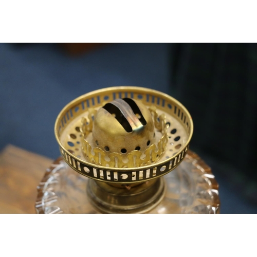 390 - Duplex oil lamp circa early 20th century with later glass shade above glass reservoir and repousse d... 