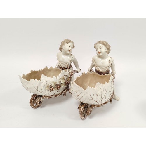 287 - Pair of 19th century Continental porcelain sweetmeat baskets modelled as putti with decorative wheel... 