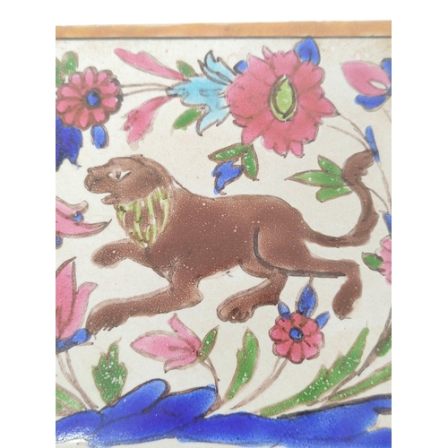 292 - Antique Persian pottery tile decorated with polychrome subject of a lion amongst foliage & flowe... 