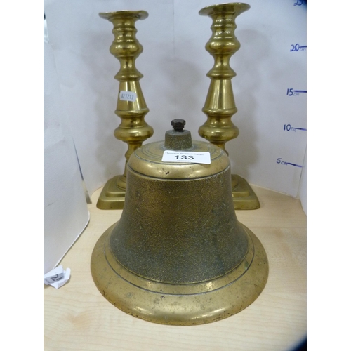 133 - Brass bell and a pair of brass candlesticks.