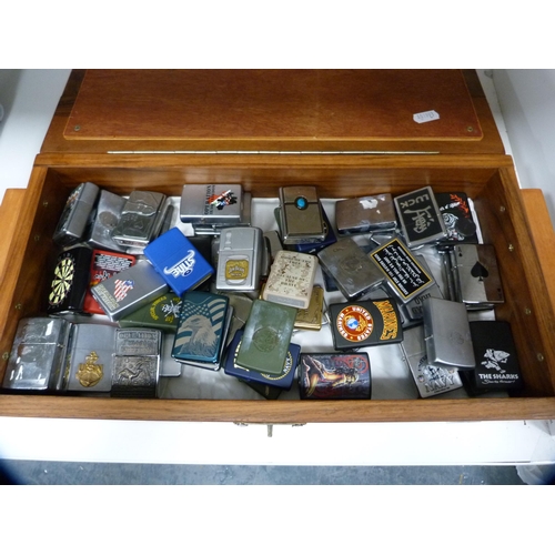 335 - Large collection of Zippo lighters contained in a burr wood box.