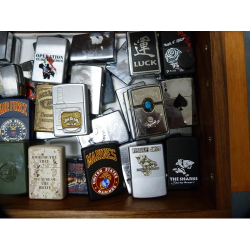 335 - Large collection of Zippo lighters contained in a burr wood box.