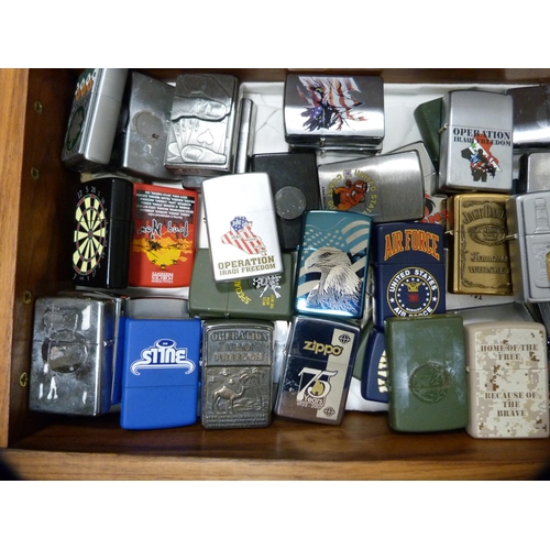 335 - Large collection of Zippo lighters contained in a burr wood box.