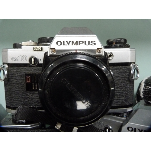 356 - Three Olympus OM10 cameras, one example with an Olympus Zoom 35-150mm lens, and an Olympus OM20 came... 