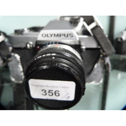 356 - Three Olympus OM10 cameras, one example with an Olympus Zoom 35-150mm lens, and an Olympus OM20 came... 