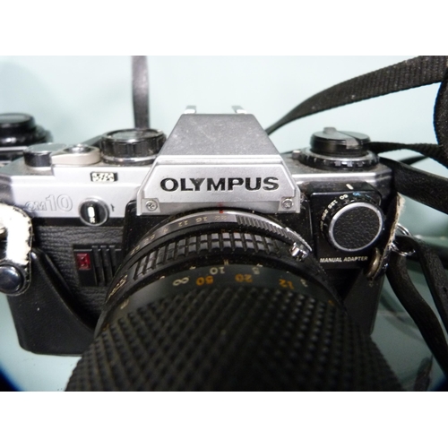 356 - Three Olympus OM10 cameras, one example with an Olympus Zoom 35-150mm lens, and an Olympus OM20 came... 