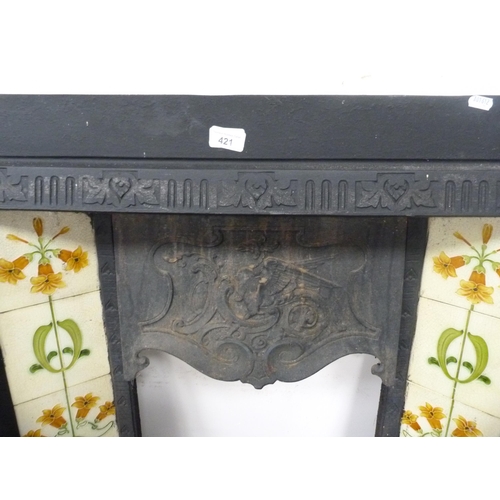 421 - Antique cast iron fire surround with tiled inserts.