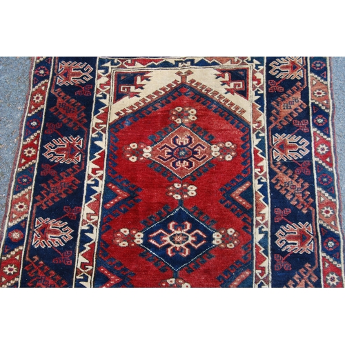 300 - Turkish hand-knotted rug with three geometric lozenges to the centre, further geometric medallions a... 