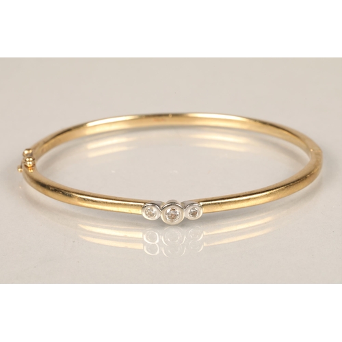 121 - Ladies 9ct yellow gold stiff bangle, set with three small diamonds, diameter 6.5cm, weight 14.3g