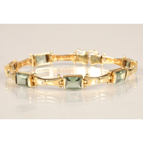 123 - Ladies 18ct yellow gold diamond and green gem stone bracelet with matching pair of earrings, length ... 