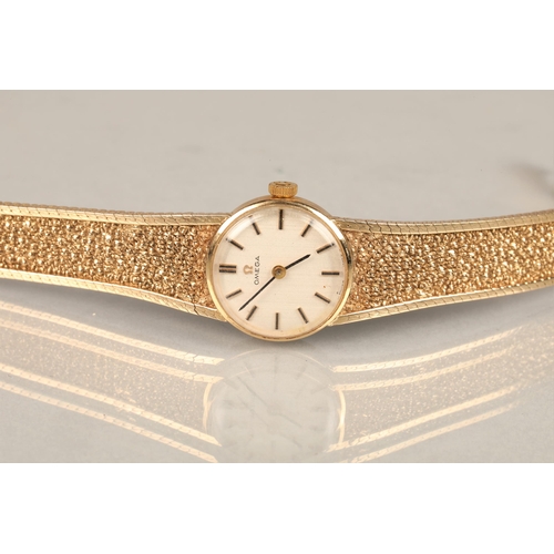 168 - Ladies 9ct yellow gold Omega wrist watch, champagne dial with hour marker batons on a textured 9ct g... 