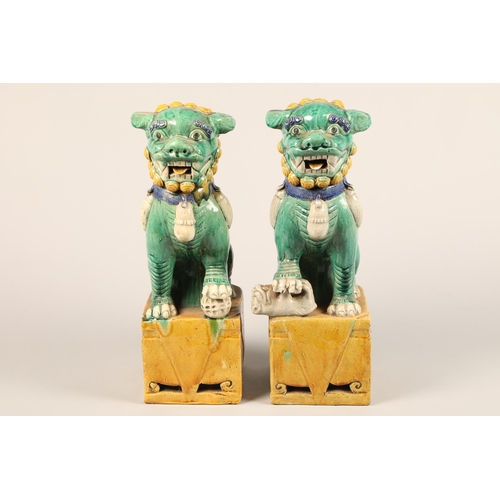 274 - Pair of large Chinese pottery figures of Buddha dogs, raised on square plinths, decorated with green... 