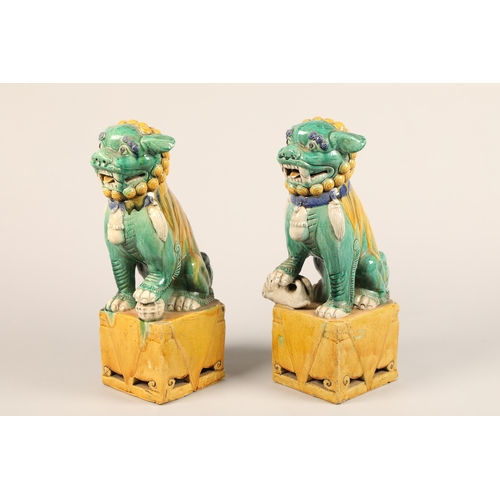 274 - Pair of large Chinese pottery figures of Buddha dogs, raised on square plinths, decorated with green... 