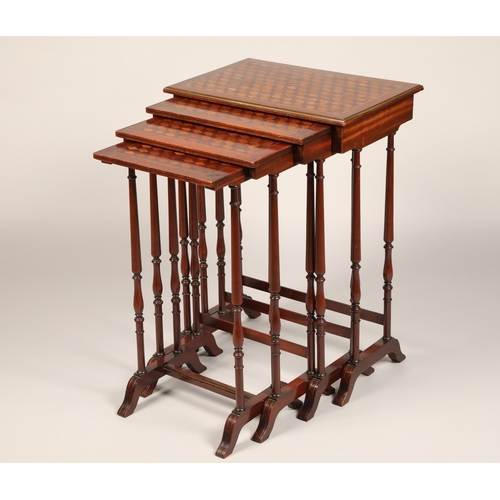 614 - Set of mahogany nest of quartet tables, the tops decorated with geometric parquetry, raised on slend... 