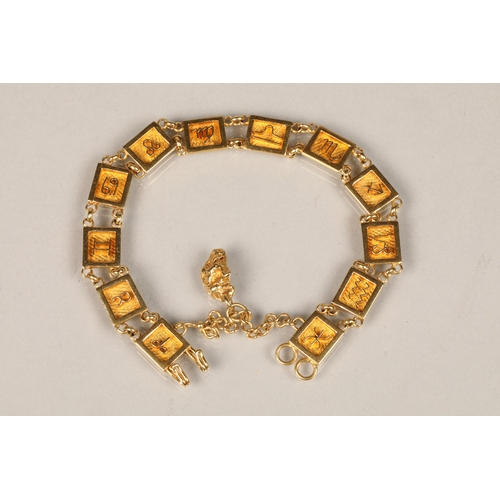 82 - Ladies unmarked yellow metal bracelet with symbols with an attached gold nugget pendant, length 19cm... 