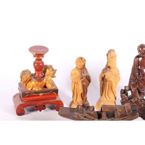 204 - Carved wooden Fu dog on footed stand, painted red and gold, 11.5cm high, a carved wooden boat on sta... 