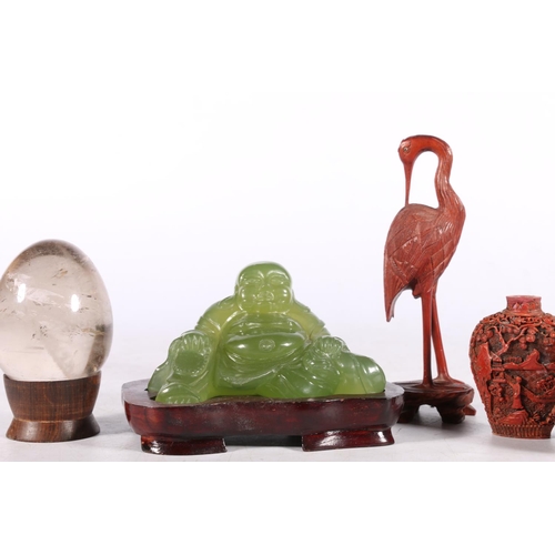 221 - Oriental decorative items comprising a Peking glass Buddha on stand 12cm wide, a rock crystal egg on... 