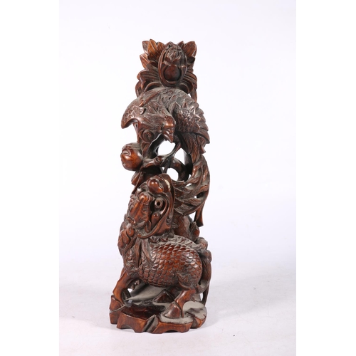 222 - Chinese root wood carving modelled as a Kylin and peacock fighting, 31cm high.