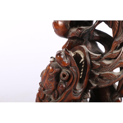 222 - Chinese root wood carving modelled as a Kylin and peacock fighting, 31cm high.