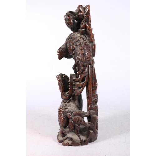 222 - Chinese root wood carving modelled as a Kylin and peacock fighting, 31cm high.