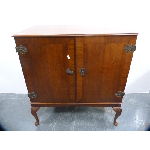 420 - Mahogany two-door cabinet with ornate hinges, on cabriole supports.