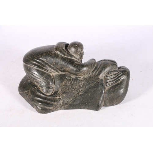 243 - Canadian Inuit serpentine or soapstone carving of a hunter with seal, 29cm long.