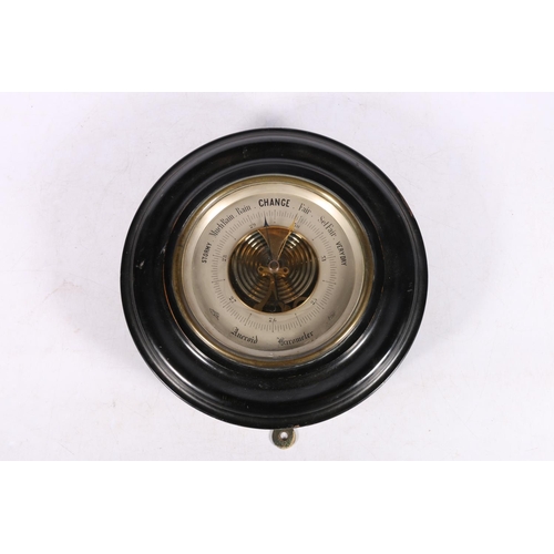 294 - Circular bulkhead barometer in ebonised frame, 27cm diameter.