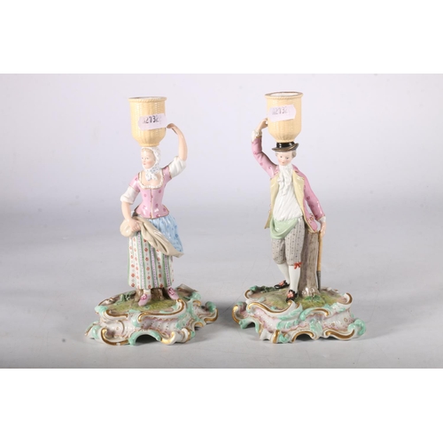 303 - Pair of 19th Century Meissen candlesticks in the form of a man and woman supporting baskets to their... 