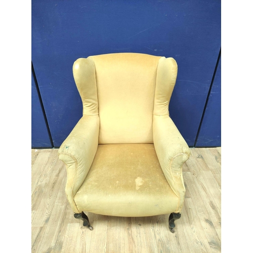 385 - Pair of early 20th century wing back armchairs upholstered in later mustard colour velour, On cabrio... 